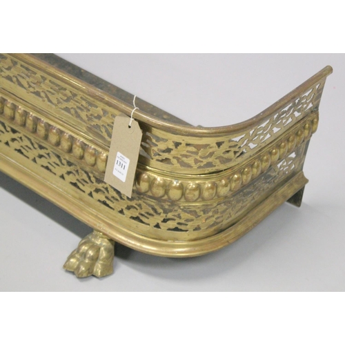 1311 - A REGENCY PIERCED BRASS FENDER with pierced decoration supported on three cast brass claw feet. 3ft ... 