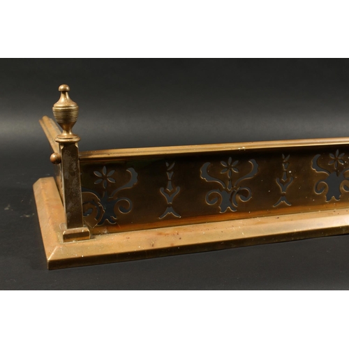 1317 - A 19TH CENTURY BRASS FENDER with pierced fretwork front and urn finials 4ft 2ins long, 1ft 1ins deep... 