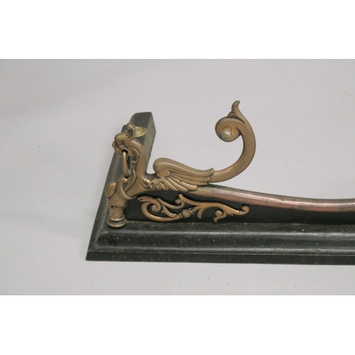 1325 - A VICTORIAN STEEL AND CAST IRON SERPENTINE SHAPED FENDER with lion ring handles. 4ft 4ins long, 1ft ... 