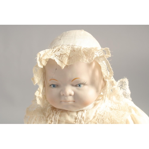 1363 - A PORCELAIN HEADED BABY DOLL. 14ins long.