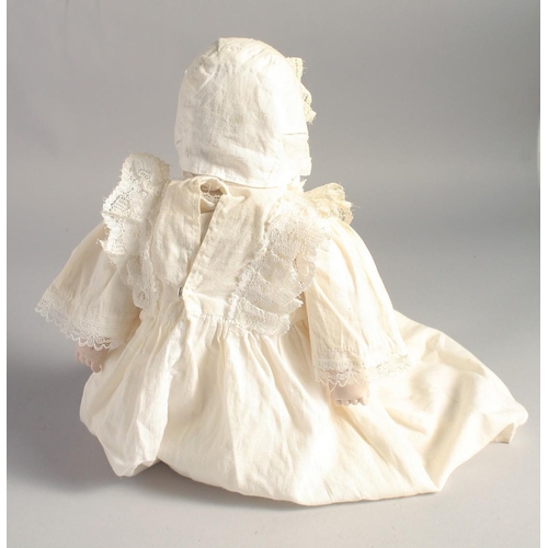 1363 - A PORCELAIN HEADED BABY DOLL. 14ins long.