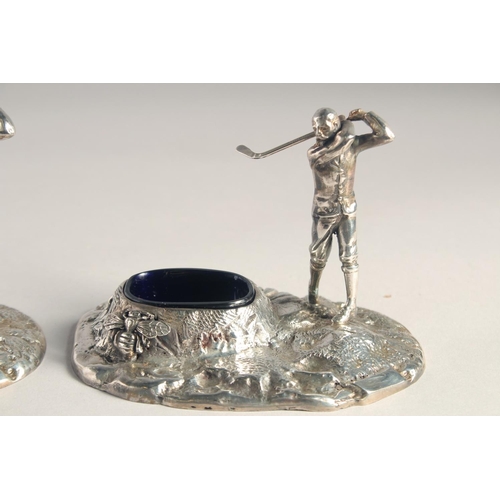 1369 - A PAIR OF SILVER PLATED GOLFER SALTS with blue liners.