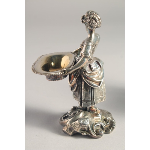 1370 - A PAIR OF SILVER PLATED YOUNG BOY AND GIRL SALTS both carrying baskets. 5.5ins high.