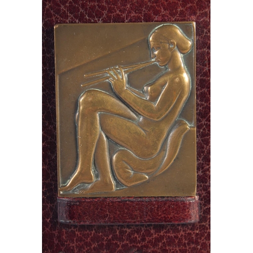 1383 - A. GUZMAN (1904 - 1943). ART DECO BRONZE MEDALS mounted on a leather nude Egyptian lady. Signed, 2.7... 