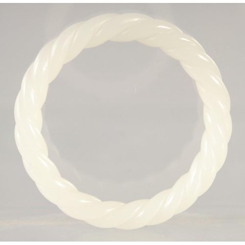 1404 - A WHITE JADE TWIST BANGLE. 3ins diameter.