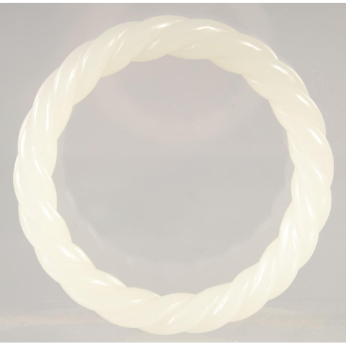 1404 - A WHITE JADE TWIST BANGLE. 3ins diameter.