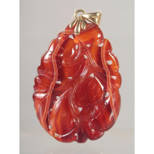 1411 - A CARVED JADE PENDANT with gold ring.