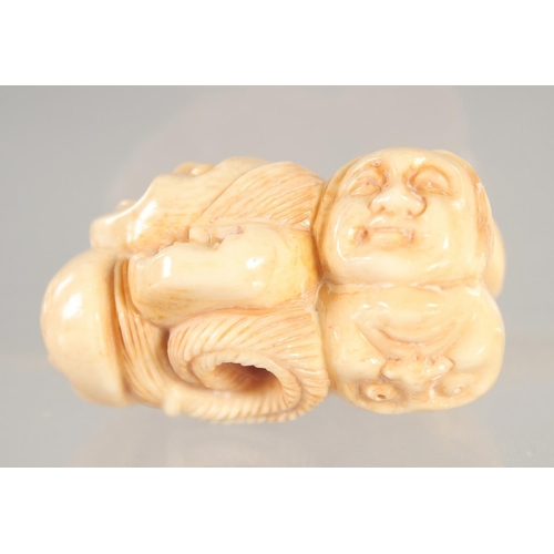 1416 - A CARVED BONE FACES NETSUKE.