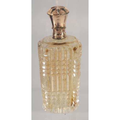 1442 - A CUT GLASS SCENT BOTTLE WITH HINGED GOLD TOP, cased. 9cm high.