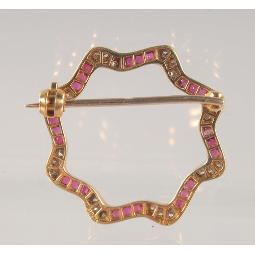 1464 - AN 18CT GOLD, DIAMOND, AND RUBY BROOCH. 2.5cm diameter.