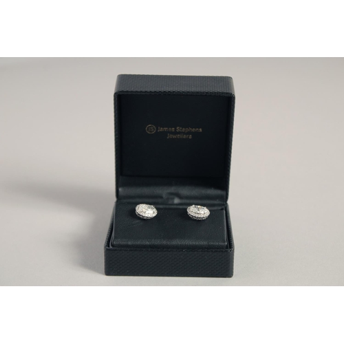 1546 - A SUPERB PAIR OF 18CT WHITE GOLD OVAL DIAMOND SET EARRINGS, the central diamonds 1.03ct to 1.02ct.