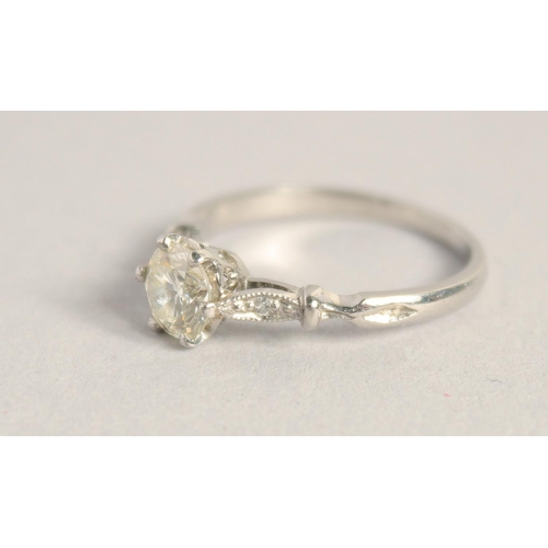 1551 - A SOLITAIRE DIAMOND RING with diamond shoulders.