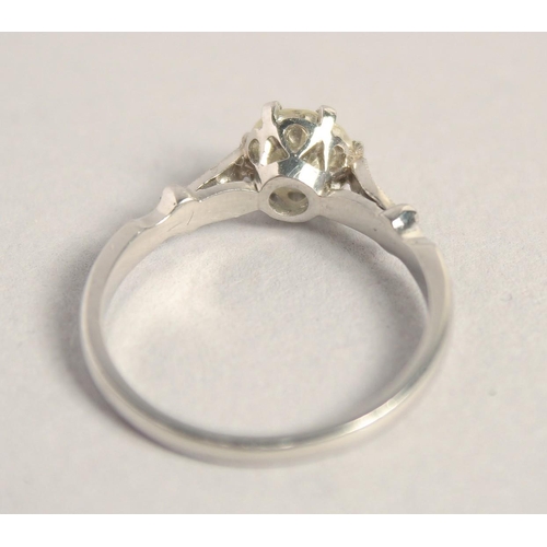 1551 - A SOLITAIRE DIAMOND RING with diamond shoulders.