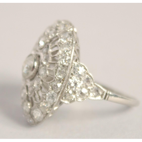 1554 - A SUPERB ART DECO PLATINUM AND DIAMOND OVAL PIERCED CLUSTER RING. 2.5cm x 2cm.