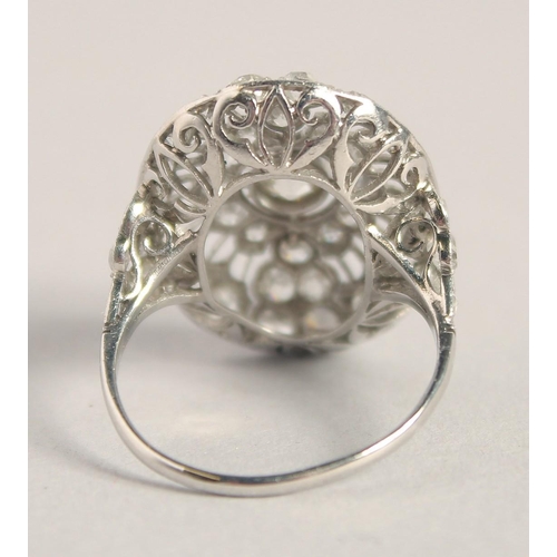 1554 - A SUPERB ART DECO PLATINUM AND DIAMOND OVAL PIERCED CLUSTER RING. 2.5cm x 2cm.