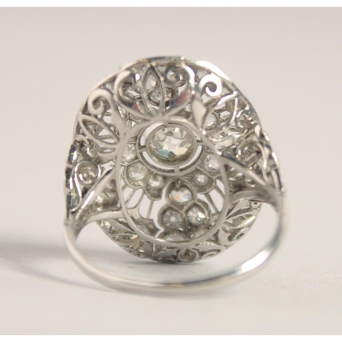 1554 - A SUPERB ART DECO PLATINUM AND DIAMOND OVAL PIERCED CLUSTER RING. 2.5cm x 2cm.