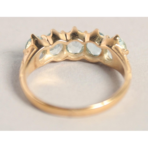 1557 - A 9CT GOLD FIVE STONE AQUAMARINE RING.