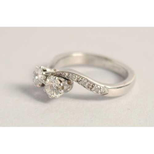 1559 - A PLATINUM TWO STONE DIAMOND CROSSOVER RING.