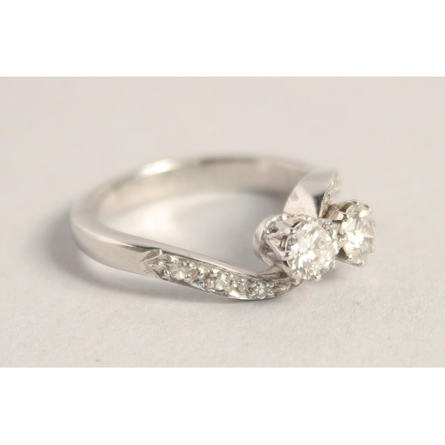 1559 - A PLATINUM TWO STONE DIAMOND CROSSOVER RING.