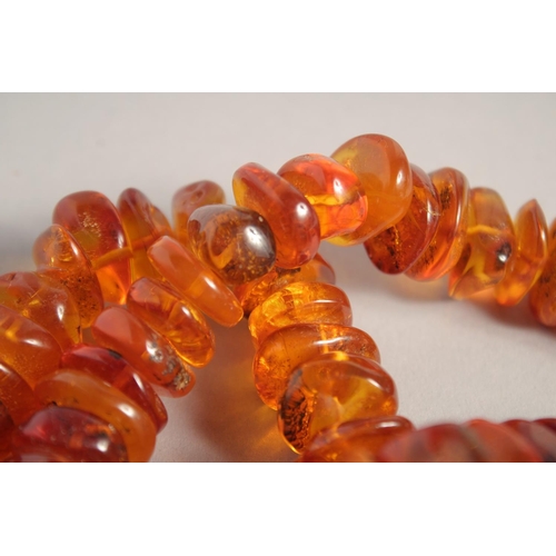 1567 - AN AMBER NECKLACE. 26ins long.