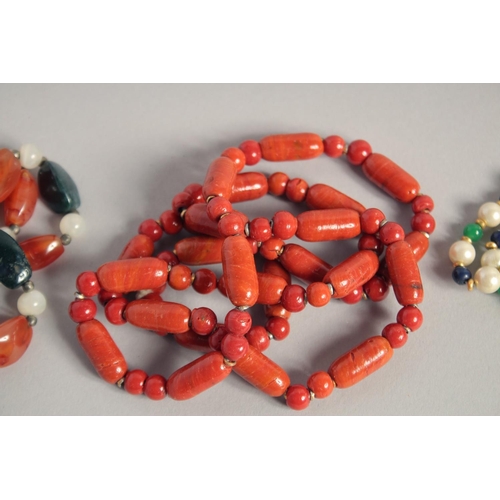 1573 - A TWO-COLOUR AGATE NECKLACE, THREE-COLOUR PEARL NECKLACE and an ORANGE STONE NECKLACE (3).