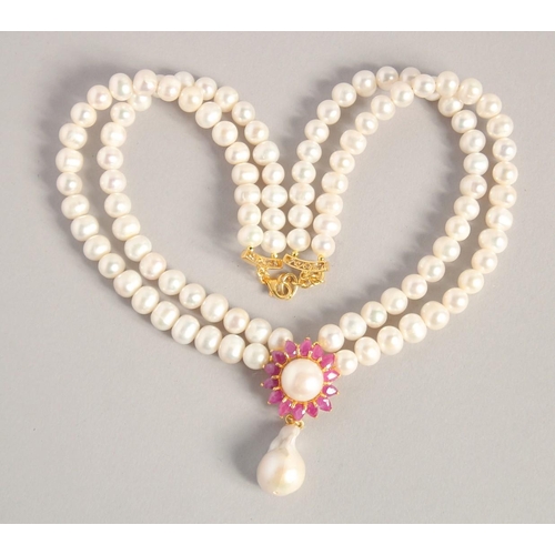 1608 - A PEARL NECKLACE with gold plated ruby and Baroque pearl clasp.