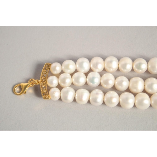 1609 - A PEARL BRACELET with GOLD PLATED RUBY CLASP.