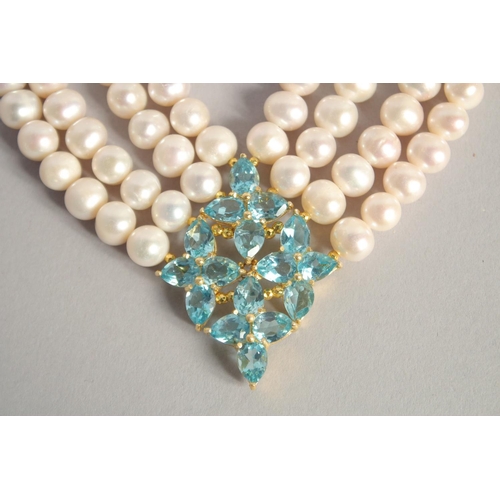 1614 - A FOUR STRAND PEARL NECKLACE with blue topaz clasp.