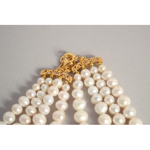 1614 - A FOUR STRAND PEARL NECKLACE with blue topaz clasp.