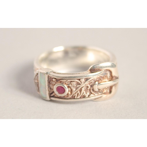 1656 - A SILVER OPAL AND RUBY BUCKLE RING.