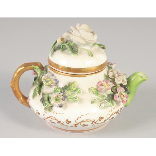 1080 - A 19TH CENTURY ROCKINGHAM MINIATURE TEA POT AND COVER encrusted with flowers, printed griffin mark.