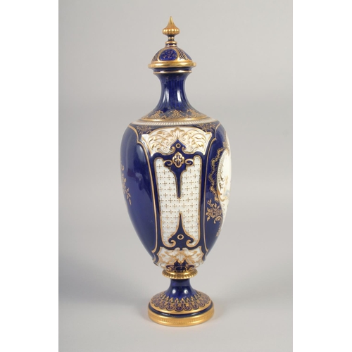 1083 - A ROYAL WORCESTER LARGE VASE painted with exotic birds in landscape on a cobalt blue ground in the m... 