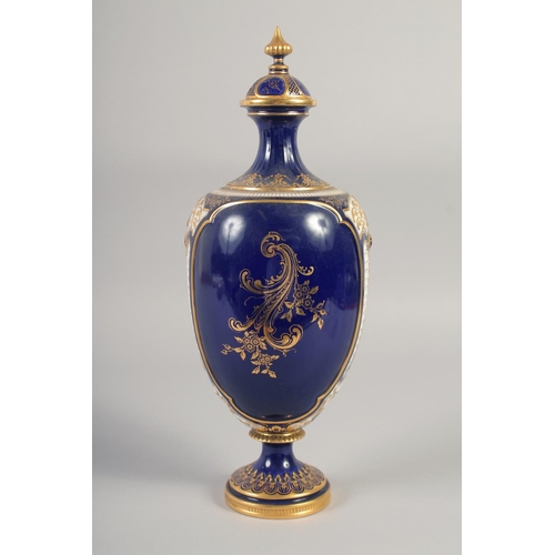 1083 - A ROYAL WORCESTER LARGE VASE painted with exotic birds in landscape on a cobalt blue ground in the m... 