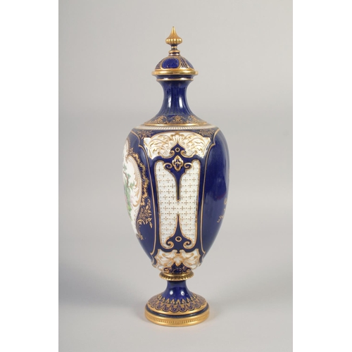 1083 - A ROYAL WORCESTER LARGE VASE painted with exotic birds in landscape on a cobalt blue ground in the m... 