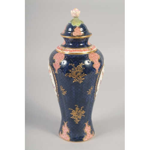 1090 - A ROYAL WORCESTER VASE AND COVER painted with flowers on a blue scale ground with red cell panels by... 