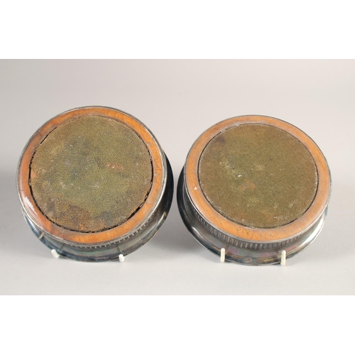 1700 - A PAIR OF GEORGE III CIRCULAR PLATED WINE COASTERS and turned wood bases. 5.25ins diameter.