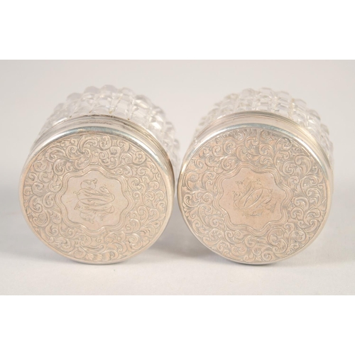 1703 - A SMALL PAIR OF VICTORIAN SILVER TOP CIRCULAR BOTTLES. 1.5ins diameter.