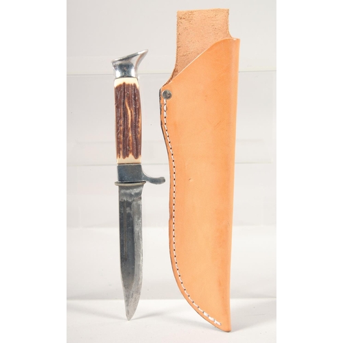 52 - A KNIFE, with thumb guard and antler handle, in a leather sheath, 8