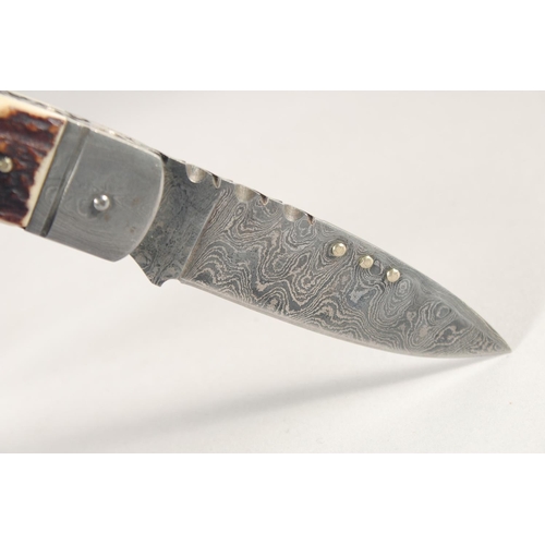 77 - AN ANTLER AND HORN HANDLED POCKET KNIFE, with Damascus blade, 5