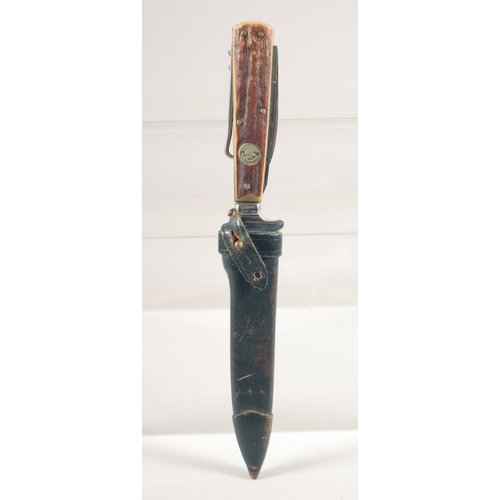 86 - A KNIFE, the antler handle with corkscrew and two knives, in a leather sheath, 8.5