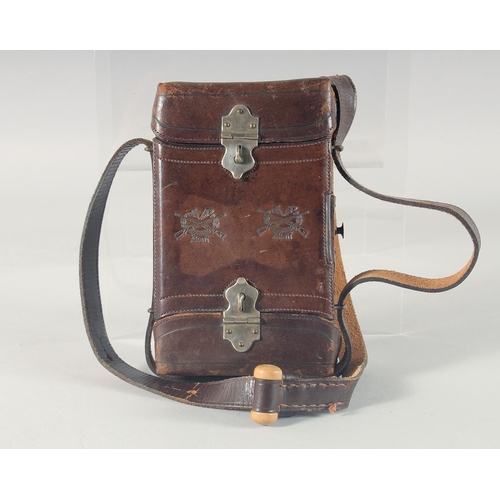 9 - A LEATHER CARTRIDGE CASE 17cm x 11cm, with cross guns in relief and leather strap.