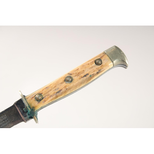 90 - A PUMA KNIFE, with antler handle, in a leather sheath. 7.5