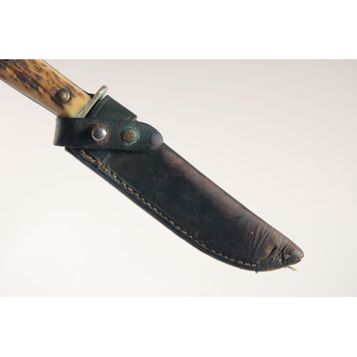 90 - A PUMA KNIFE, with antler handle, in a leather sheath. 7.5