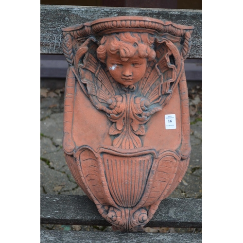 16 - A terracotta coloured garden wall font with cherub face.