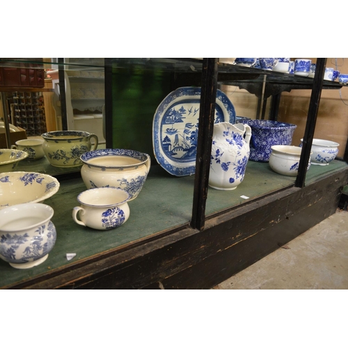 171 - A quantity of blue and white china to include a foot bath, chamber pot, large jug, meat plate etc.