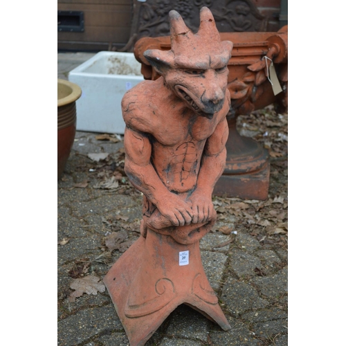 20 - A terracotta coloured garden ornament modelled as a gargoyle on a ridge tile.