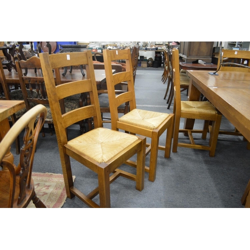 245 - A set of eight oak and rush seated dining chairs.