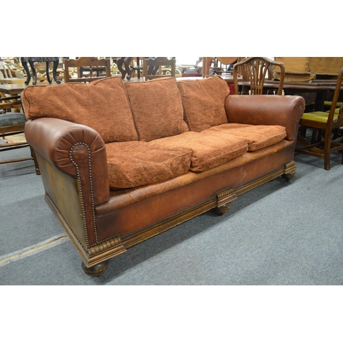 263 - An oak framed leather cloth and upholstered three seater settee.