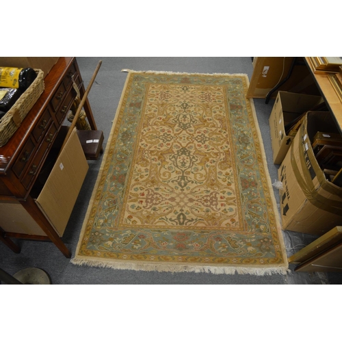 304 - A cream ground rug with a floral decoration 6' x 3' 10