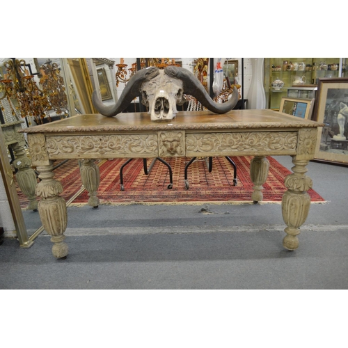 332 - A Victorian carved and painted two drawer writing table with leather inset top.